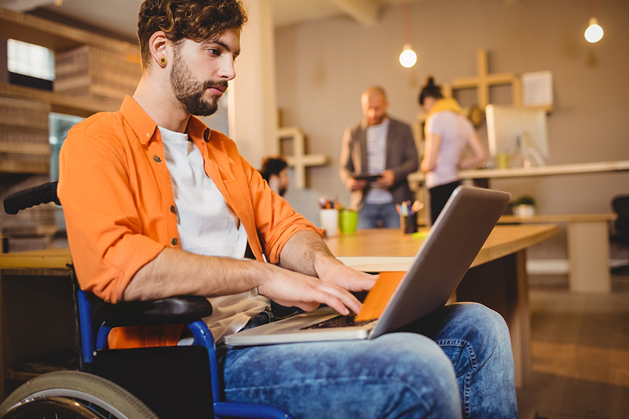 una persona en silla de ruedas trabajando desde su portatil desempeñando un empleo para discapacitados