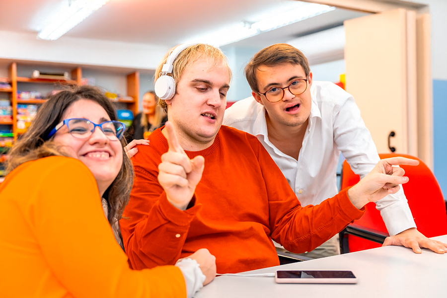 Grupo de jóvenes con distintos grados de discapacidad disfrutando en un aula inclusiva, representando la importancia del acceso a la educación superior con apoyos y oportunidades adaptadas.