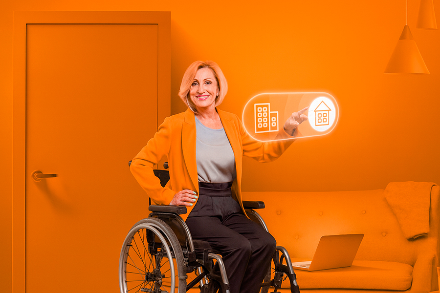 Mujer en silla de ruedas usando tecnología domótica en un hogar inteligente, ejemplo de accesibilidad adaptada al futuro sin barreras.