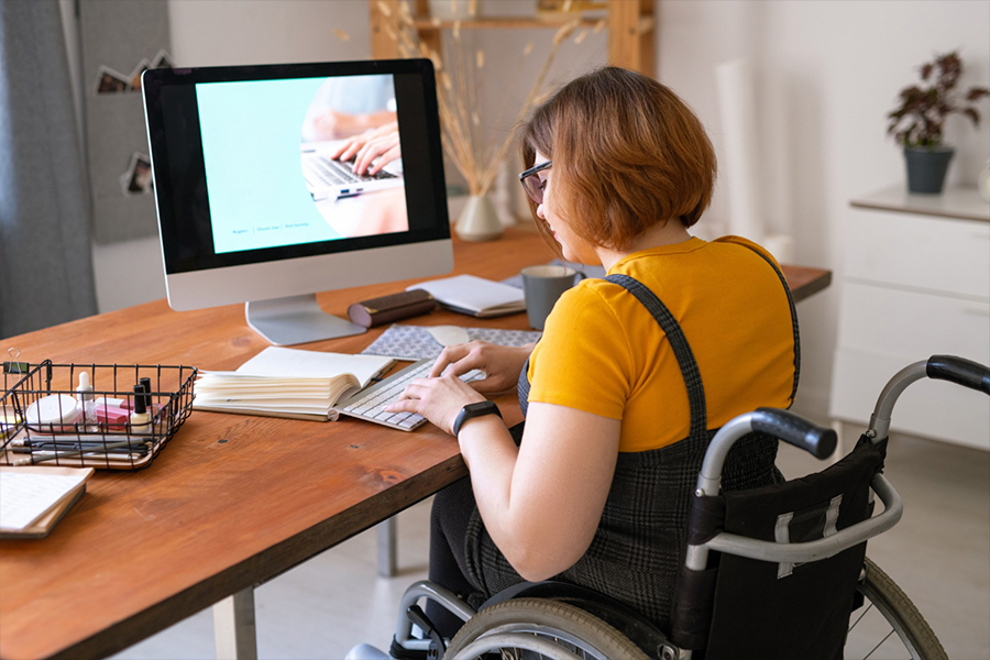 Persona con diversidad funcional trabajando desde casa con su ordenador, ejemplo de inclusión laboral y oportunidades del teletrabajo digital.