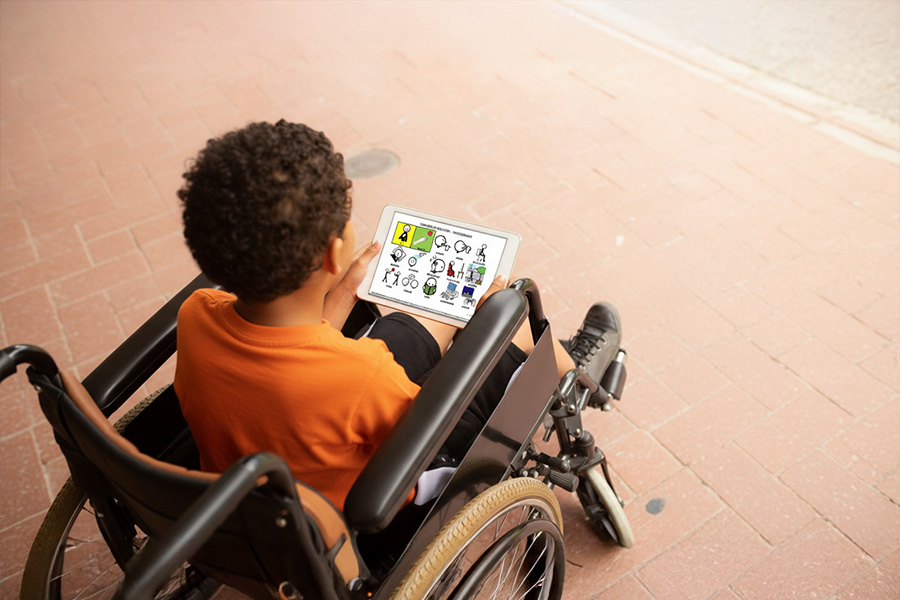 Persona utilizando una tableta con pictogramas y tecnologías de comunicación aumentativa, mostrando soluciones adaptadas a distintos tipos de discapacidad.